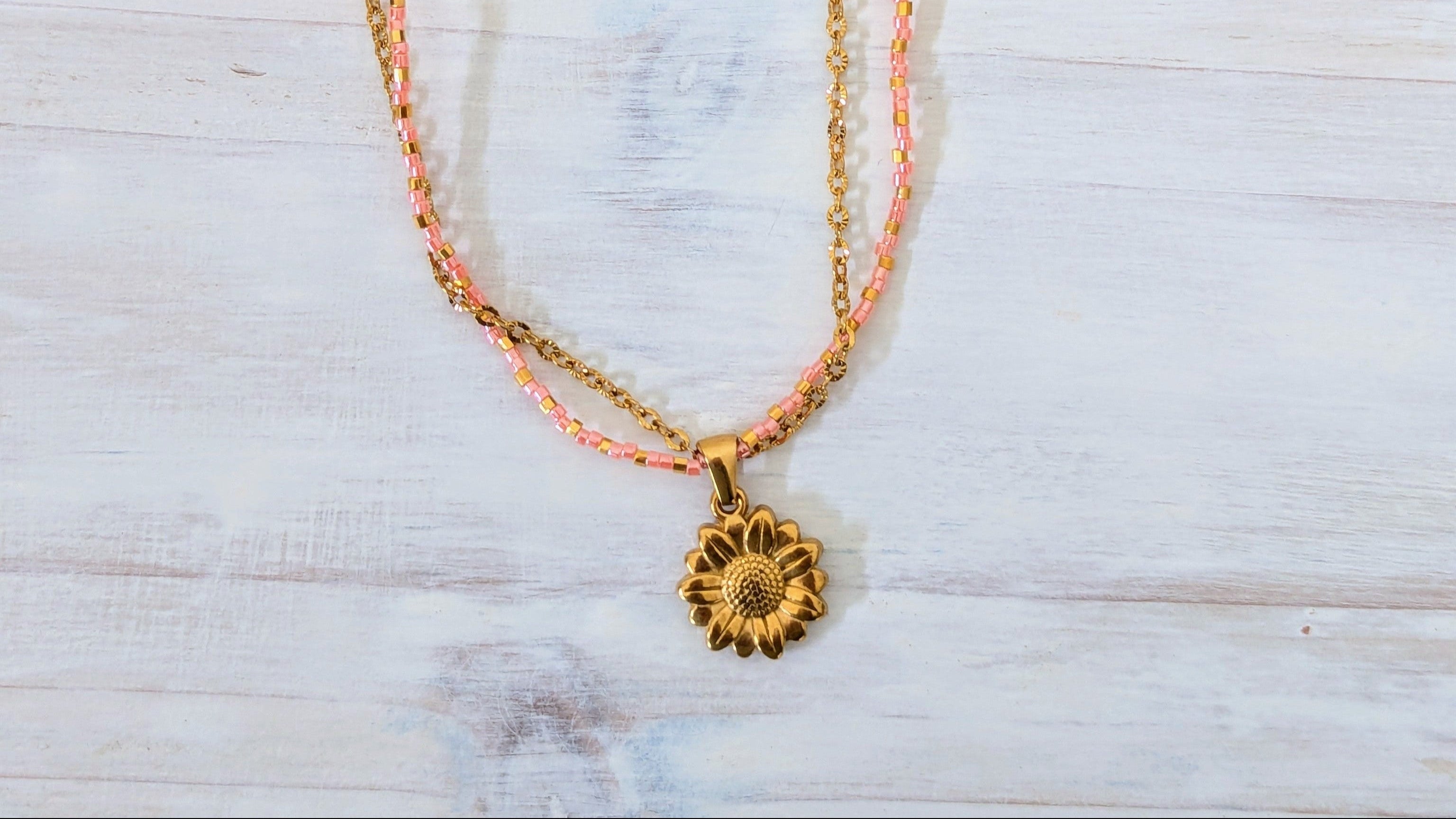 Necklace with a sunflower pendant on a white surface
